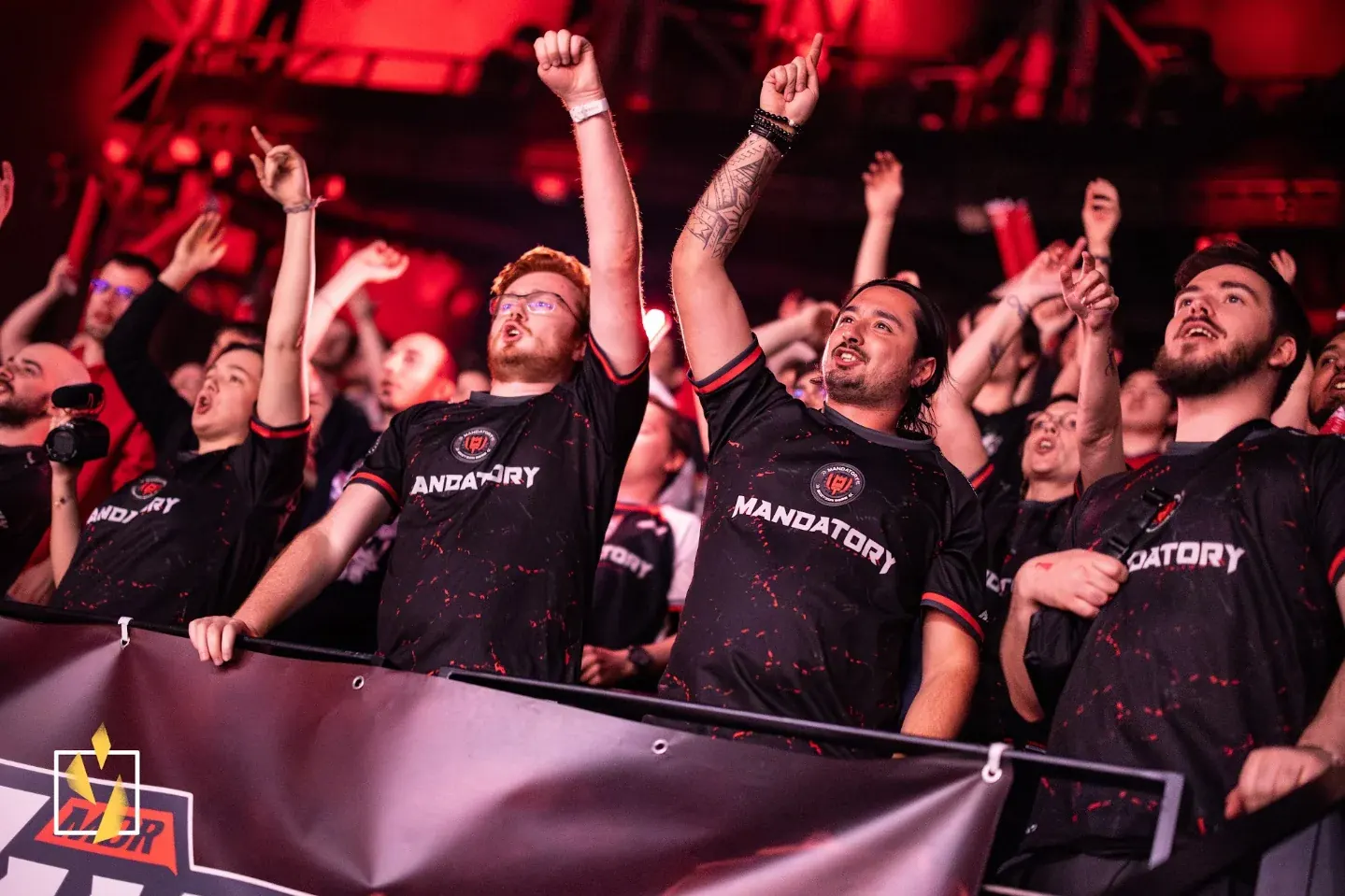 Supporters en tribune, bras levés, jerseys Mandatory